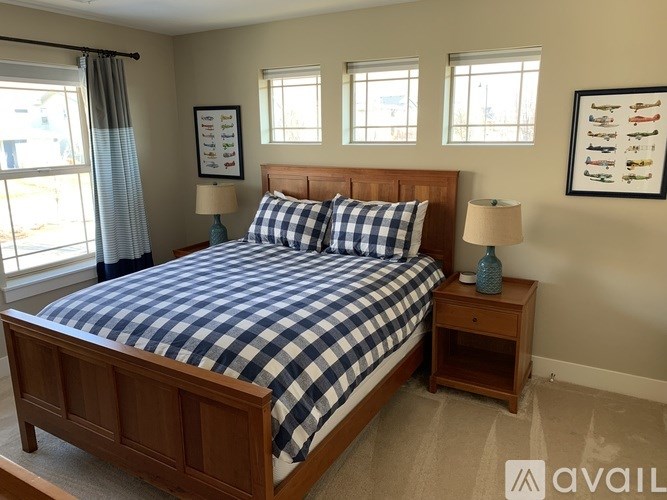A bedroom with a bed, nightstands, and two windows.