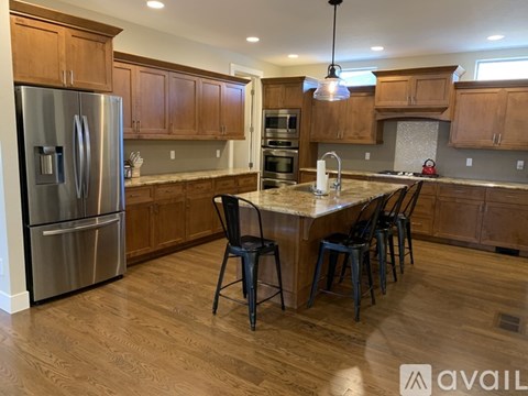A kitchen with wooden cabinets and a stainless steel refrigerator.