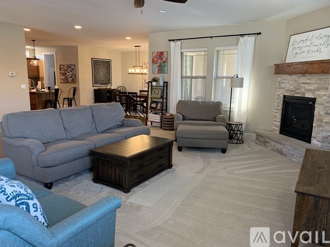 A living room with a grey couch, a coffee table, and a fireplace.