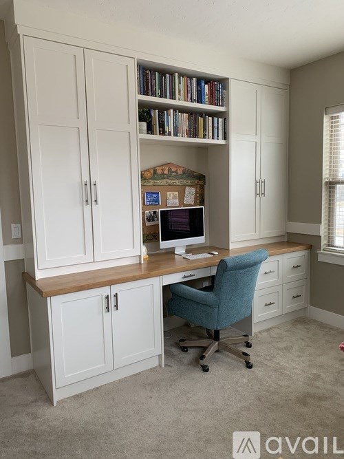 A home office with a desk, chair, and bookshelf.