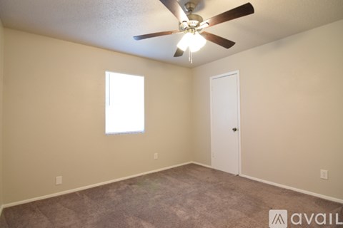 A room with a ceiling fan and a window.