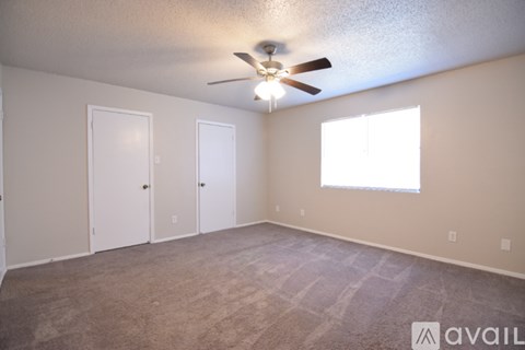 A room with a ceiling fan and carpeted floor.