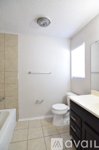 A bathroom with a toilet, sink, and bathtub.