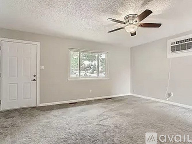 A room with a ceiling fan and a window.