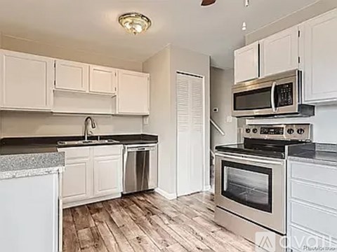 A kitchen with white cabinets and stainless steel appliances.