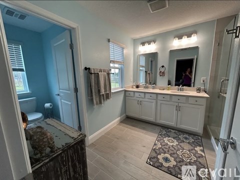 A bathroom with a toilet, sink, and mirror.