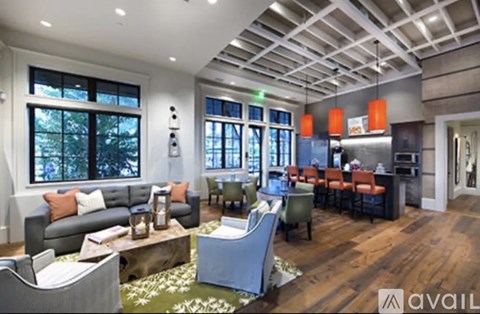 A modern living room with a grey sofa and a wooden floor.