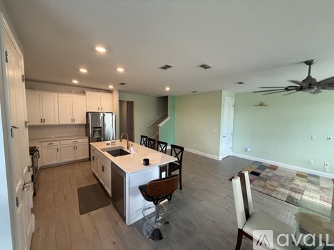 A kitchen with a center island and a dining table with chairs.