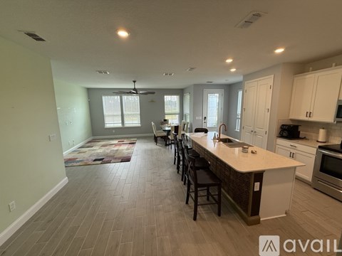 A kitchen with a long island and chairs.