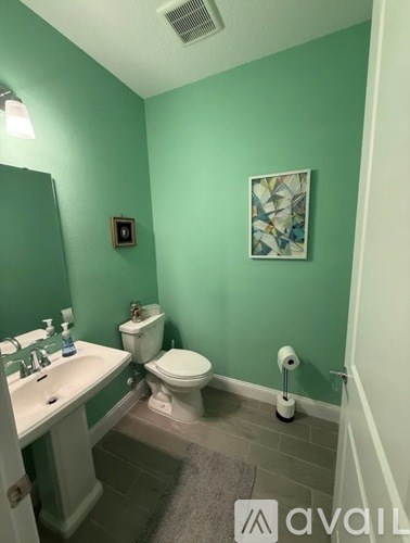 A bathroom with green walls and a white toilet.