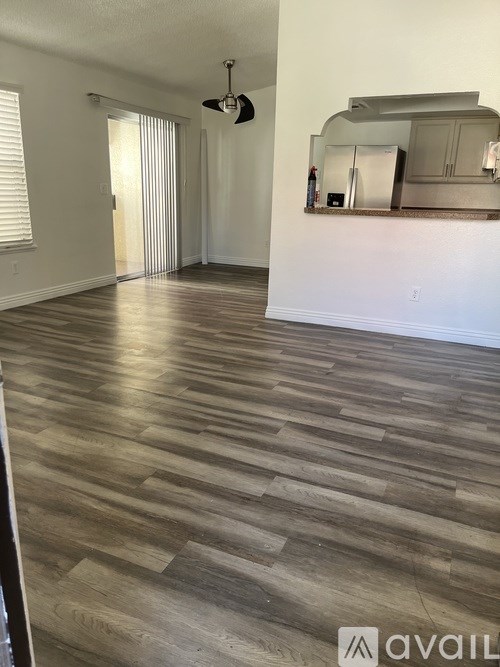 A room with wooden flooring and a ceiling fan.