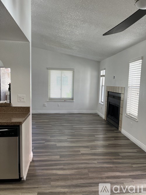 A living room with a fireplace and a dishwasher.