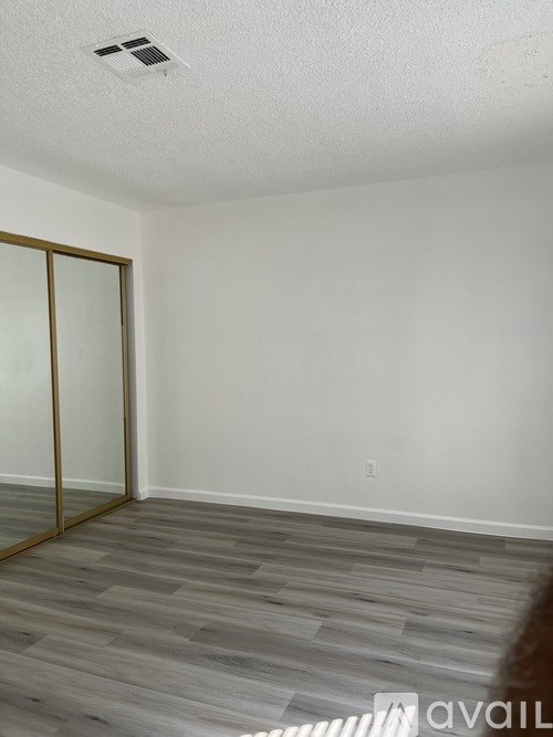 A room with a wooden floor and a glass door.