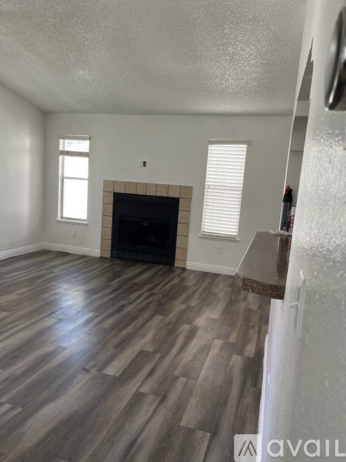 A living room with a fireplace and wood flooring.