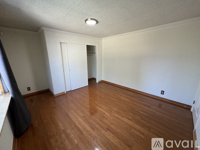 A room with wooden flooring and white walls.