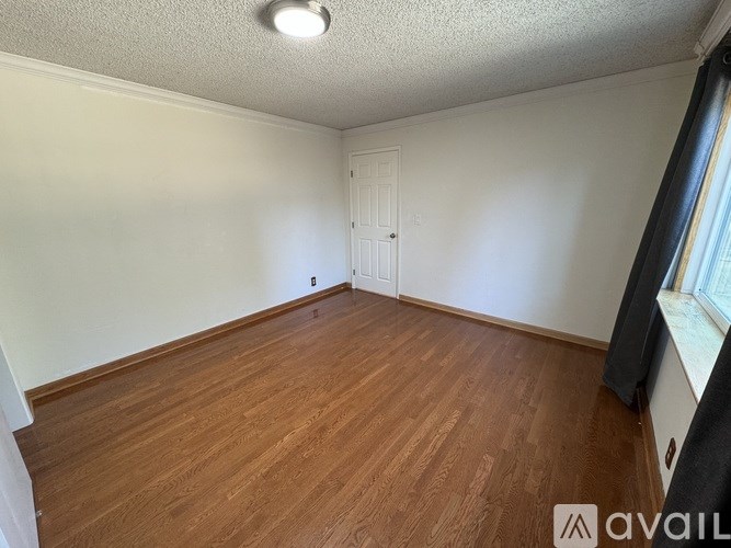 A room with wooden flooring and a white door.
