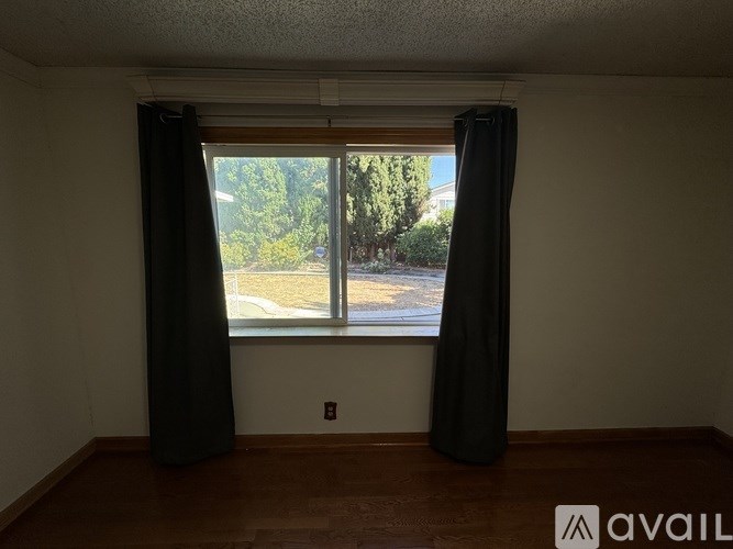 A room with a window and black curtains.