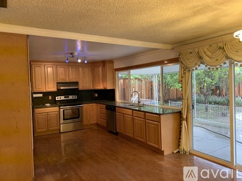 A kitchen with wooden cabinets and a black countertop.