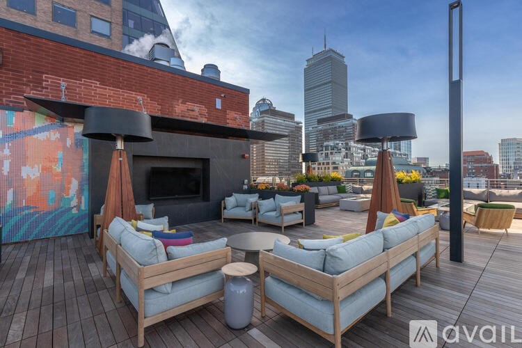 A wooden deck with a couch and a table with a vase on it.