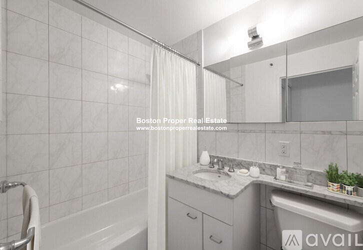 A bathroom with a tub, sink, and mirror.