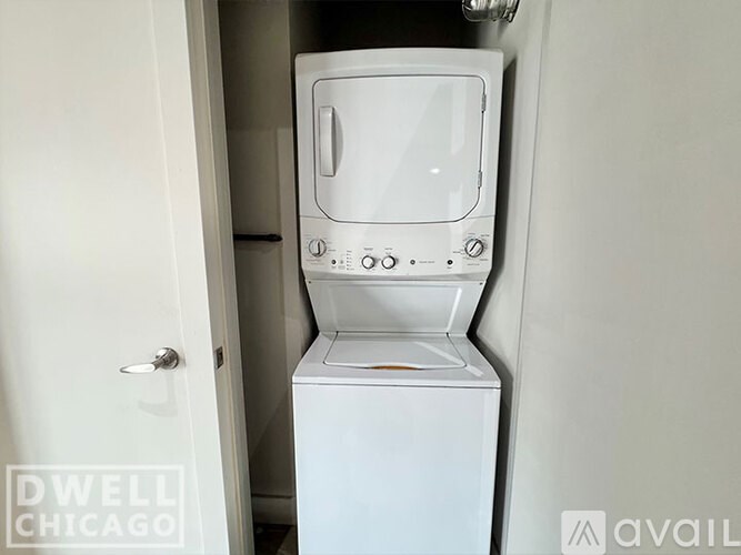 A white Dwell Chicago fridge is in a white doorway.