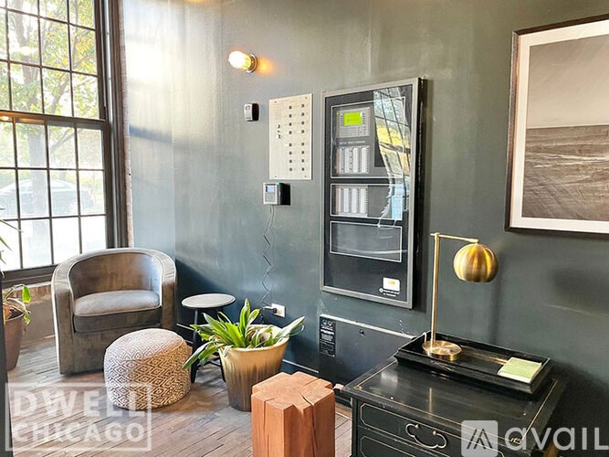 A room with a chair, a table, and a fridge.