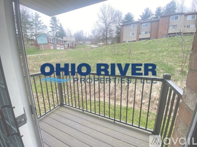 A balcony with a view of a residential area and a sign that reads "OHIO RIVER PROPERTIES LLC".