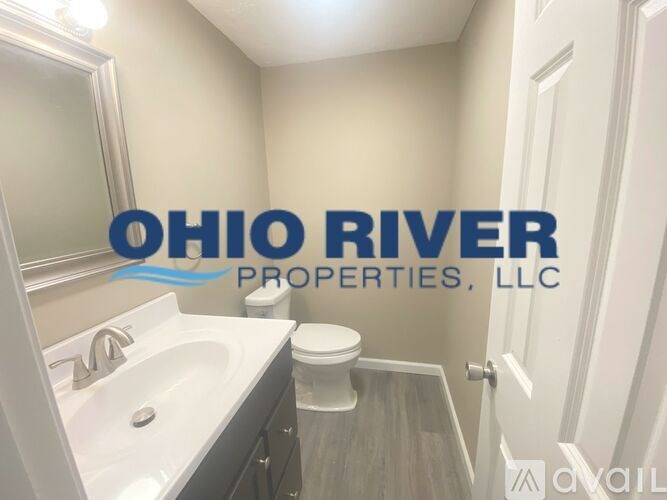 A bathroom with a sink, toilet and a mirror.