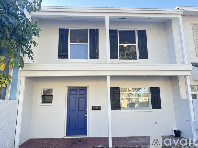 A two-story house with a blue door and windows.