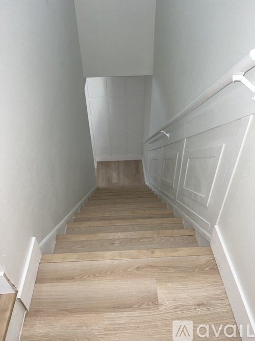 A staircase with wooden steps and white walls.
