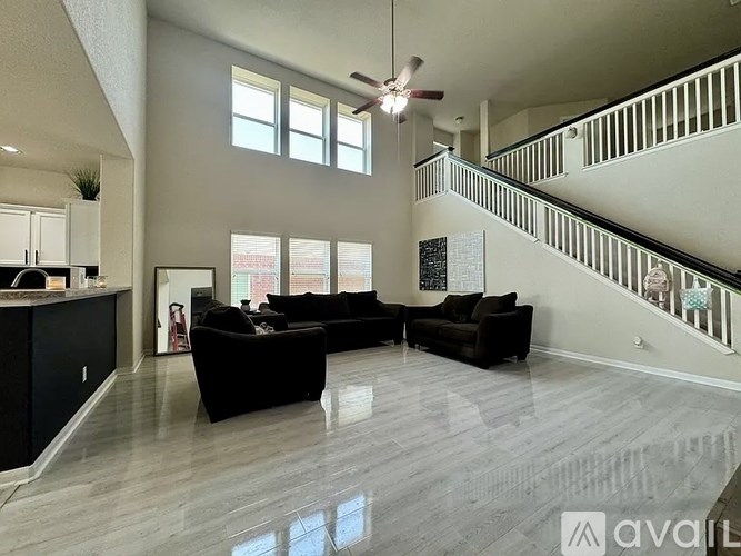 A spacious living room with a staircase on the right side.