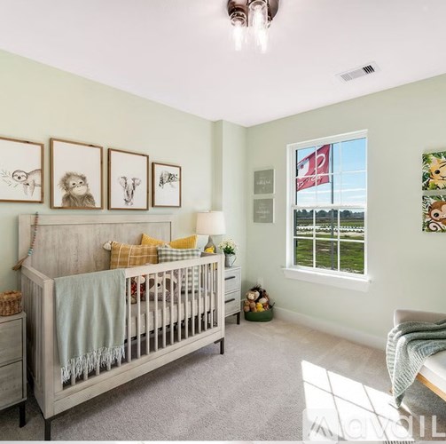 A baby's room with a crib, a dresser, and pictures on the wall.