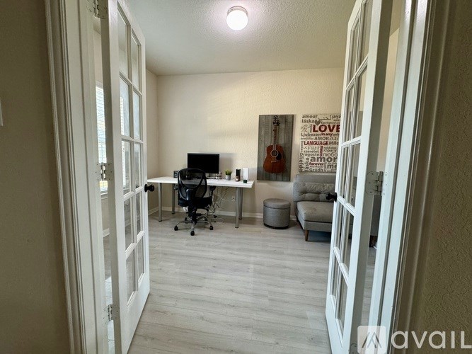 A room with a desk and a chair in it.