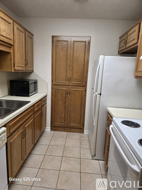A kitchen with wooden cabinets and a white refrigerator.