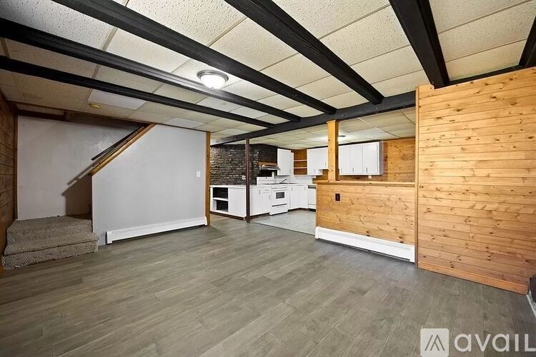 A room with wooden walls and a staircase leading to the upper floor.