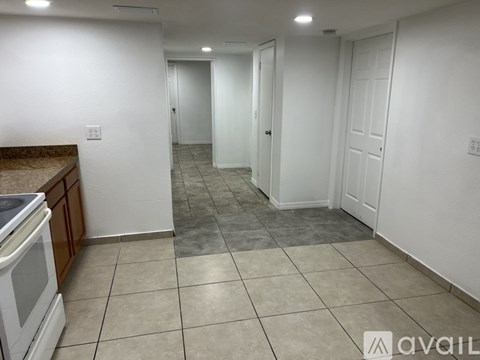 A kitchen with white cabinets and a tiled floor.