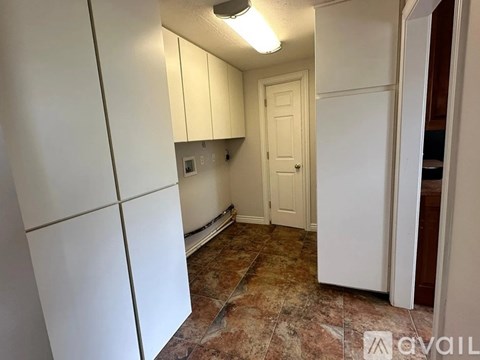 A kitchen with white cabinets and a tiled floor.