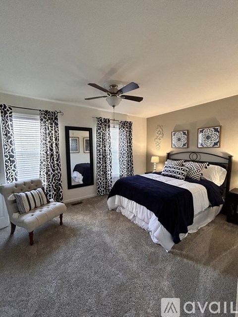 A bedroom with a large bed and a chair.