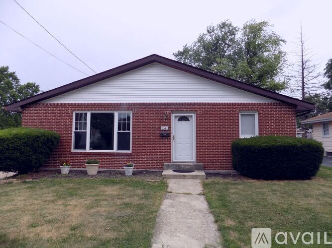 A red brick house with a white door and windows.