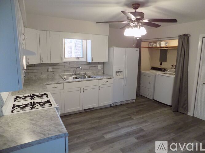 A kitchen with a stove top oven and a refrigerator.