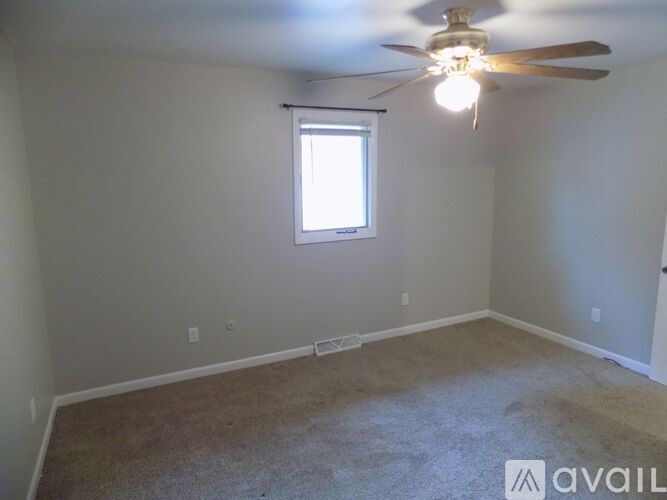 A room with a ceiling fan and a window.