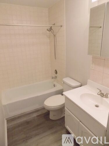 A bathroom with a toilet, sink, and bathtub.