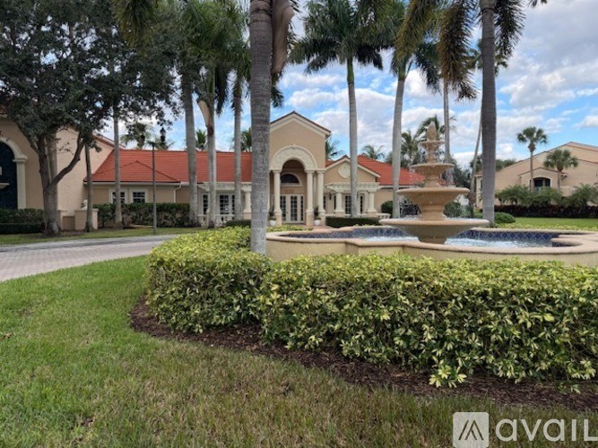 A building with a fountain in front of it surrounded by greenery.