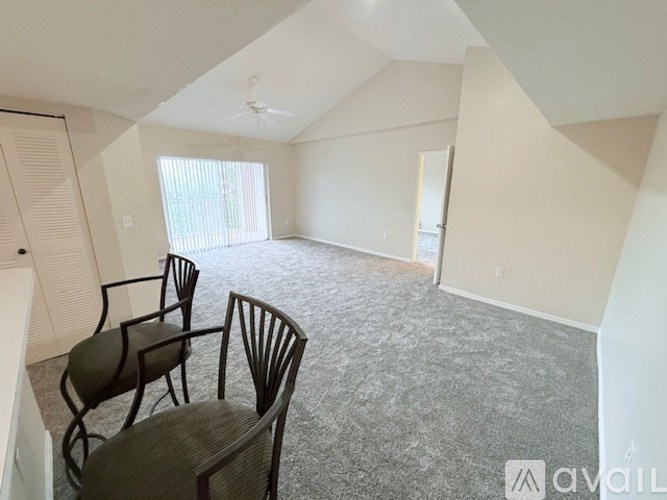A room with a carpeted floor and a table with chairs.
