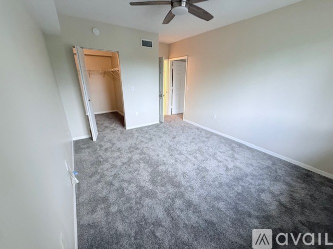 A room with a ceiling fan and carpeted floor.