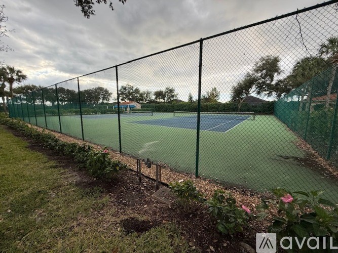 A tennis court is enclosed by a chain-link fence.