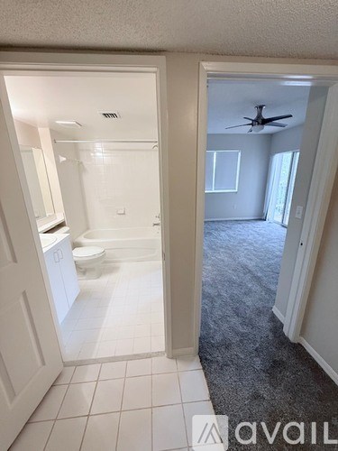 A bathroom with a toilet, sink, and a fan.