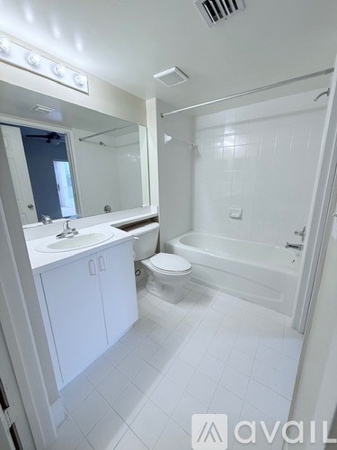 A white bathroom with a toilet, sink, and bathtub.