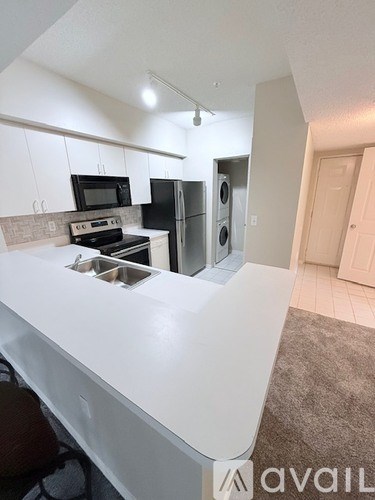 A kitchen with white countertops and a sink.