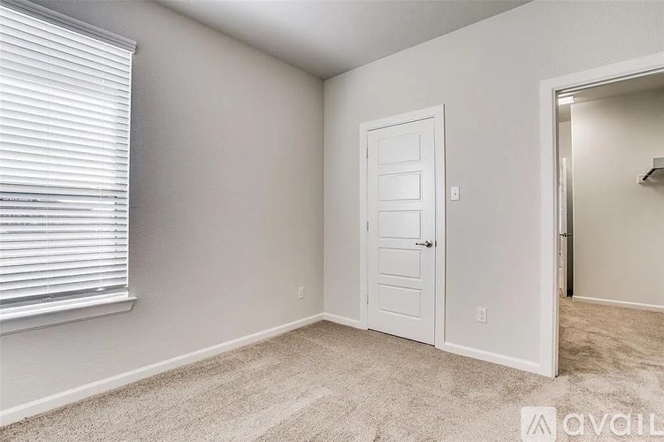 A room with a white door and carpeted floor.